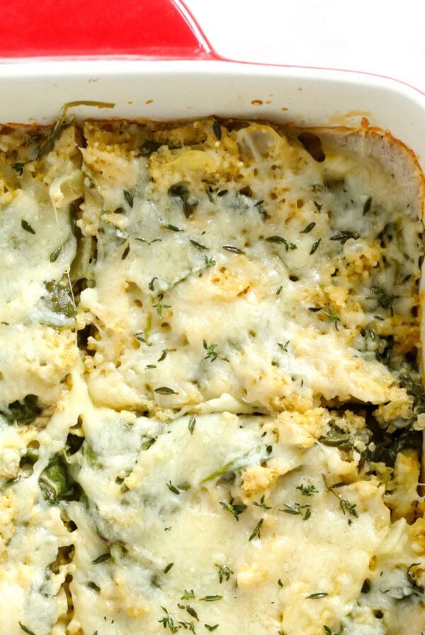 cheesy spinach casserole in a red and white dish.