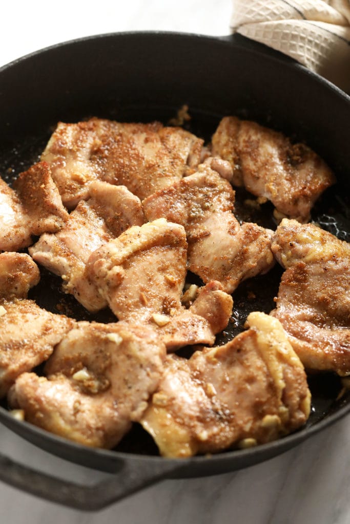 boneless chicken thighs in a cast iron skillet with a dry rub