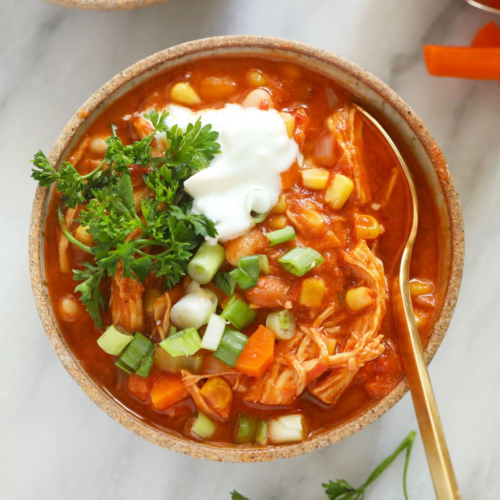 a vessel  of buffalo chickenhearted  chili with sour pick  and carrots.