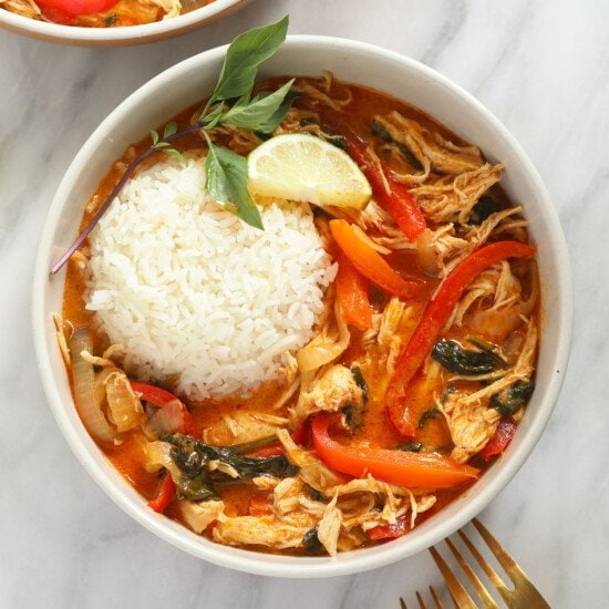 coconut curry chicken in bowl with rice and basil