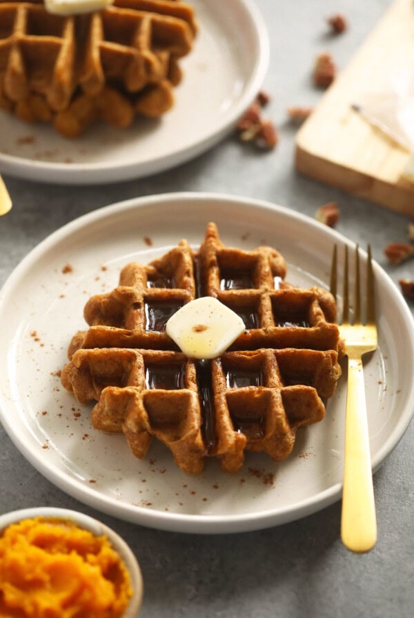 pumpkin waffle on plate with fork and butter