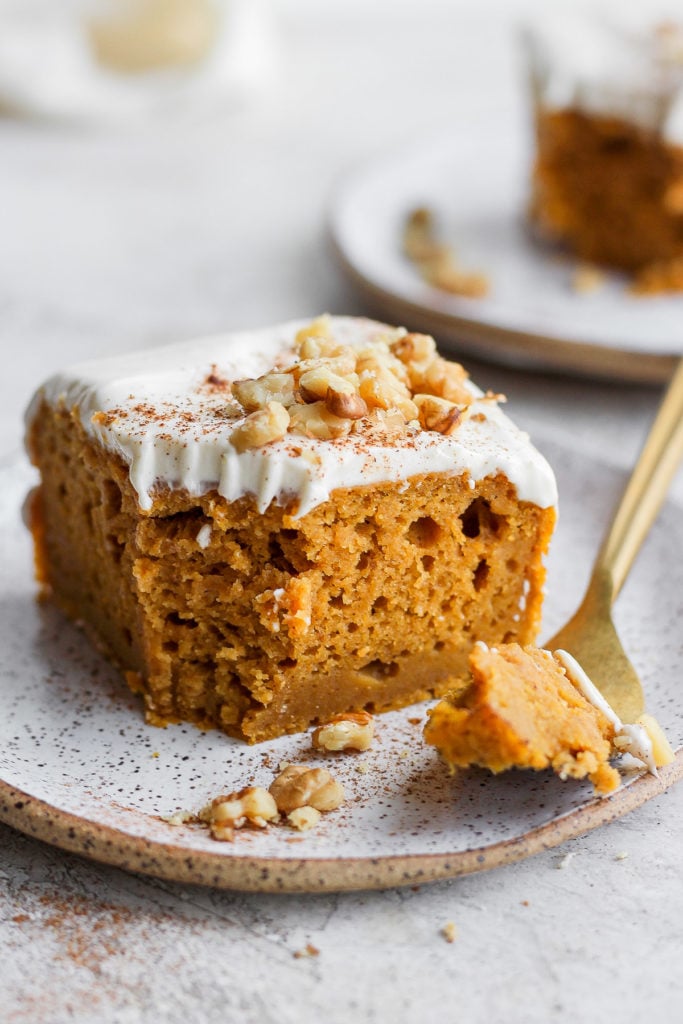 slice of pumpkin sheet cake on a plate with a bite ready to eat on a fork