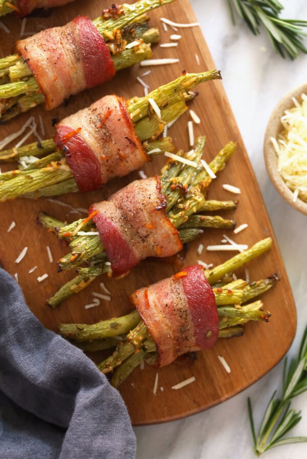 bacon wrapped green beans on a wooden platter