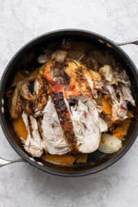 roasted chicken in a skillet on a white background.