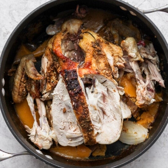 roasted chicken in a skillet on a white background.