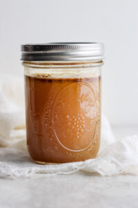 caramel sauce in a jar on a white cloth.