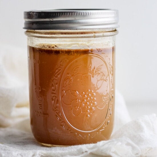 caramel sauce in a jar on a white cloth.