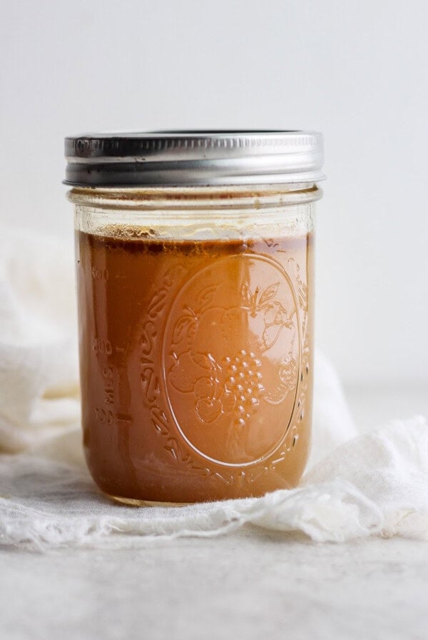 caramel sauce in a jar on a white cloth.
