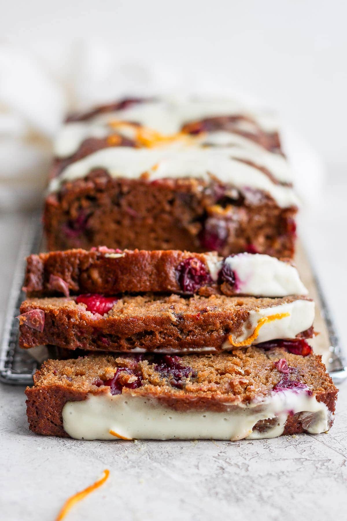 cranberry orange bread with a cream cheese glaze cut into slices