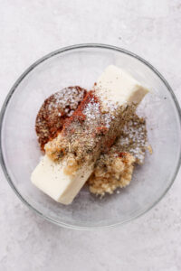 A glass bowl with a scoop of ice cream and spices resembling a whole roasted chicken.