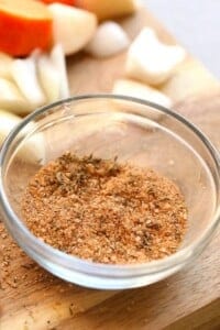 An Instant Pot Pork Roast seasoned with onions and garlic, displayed on a cutting board.