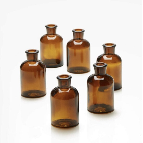 a set of brown glass bottles on a white surface.
