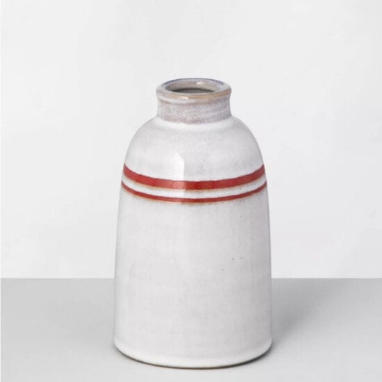a white vase with a red stripe on it.