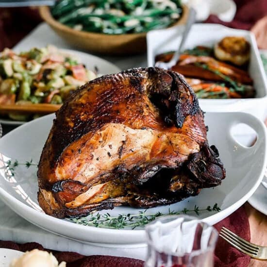 Thanksgiving dinner with Sous Vide turkey and roasted vegetables on a table.