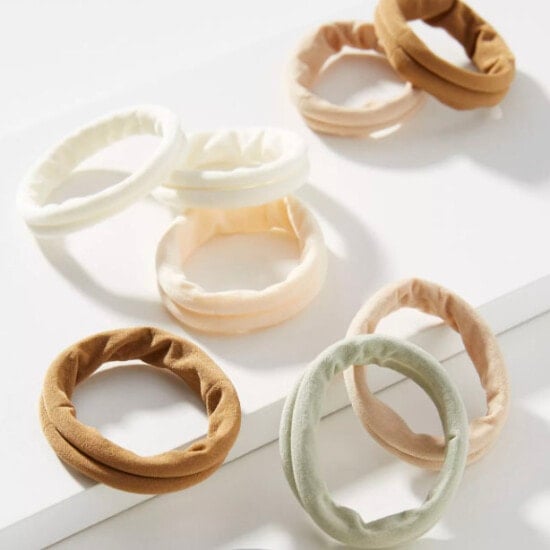 a set of beige and brown hair ties on a white surface.