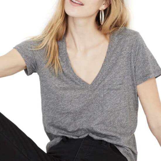 a woman in black jeans and a grey v - neck tee.