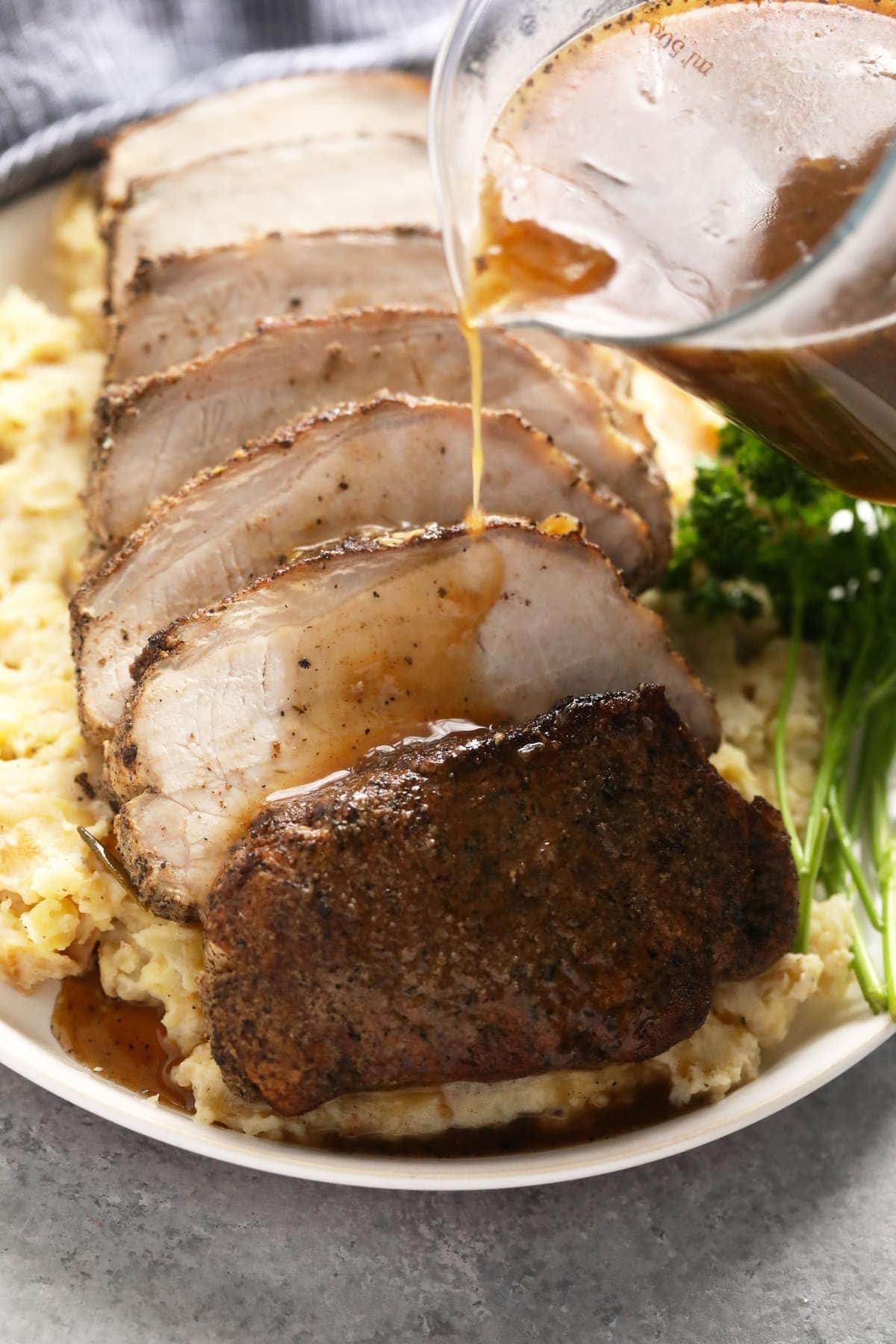 slow cooker pork loin sliced on a bed of mashed potatoes.