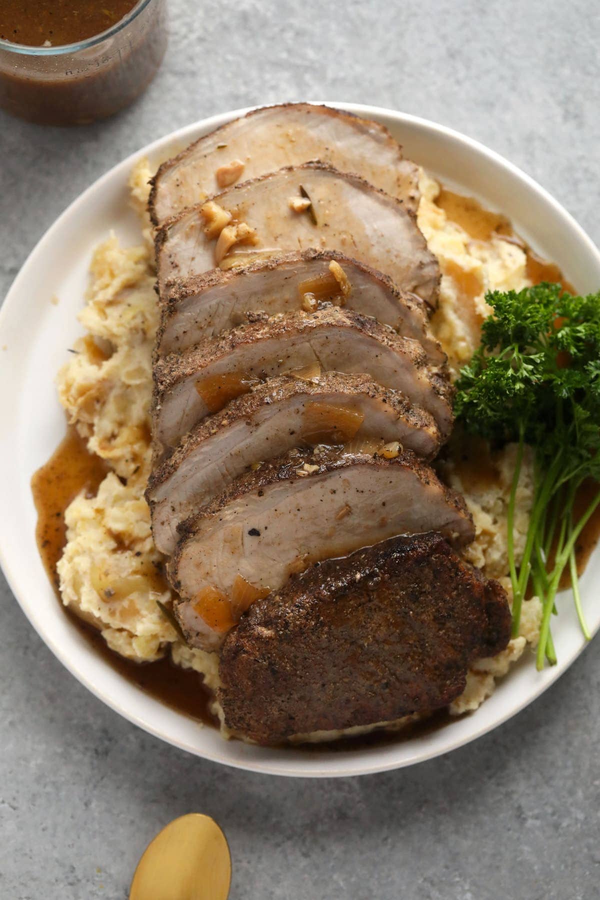 slow cooker pork loin on a bed of mashed potatoes covered in delicious homemade gravy.