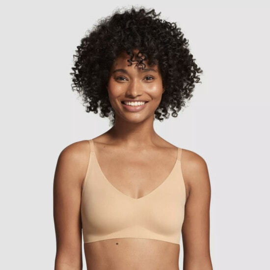 a woman in a tan bikini is smiling.