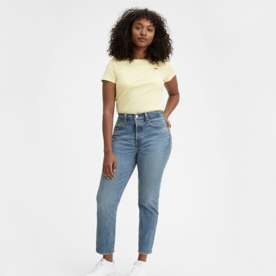 a model is wearing a yellow t - shirt and jeans.