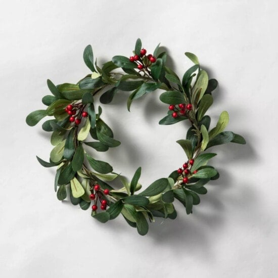 a holly wreath with red berries on a white background.