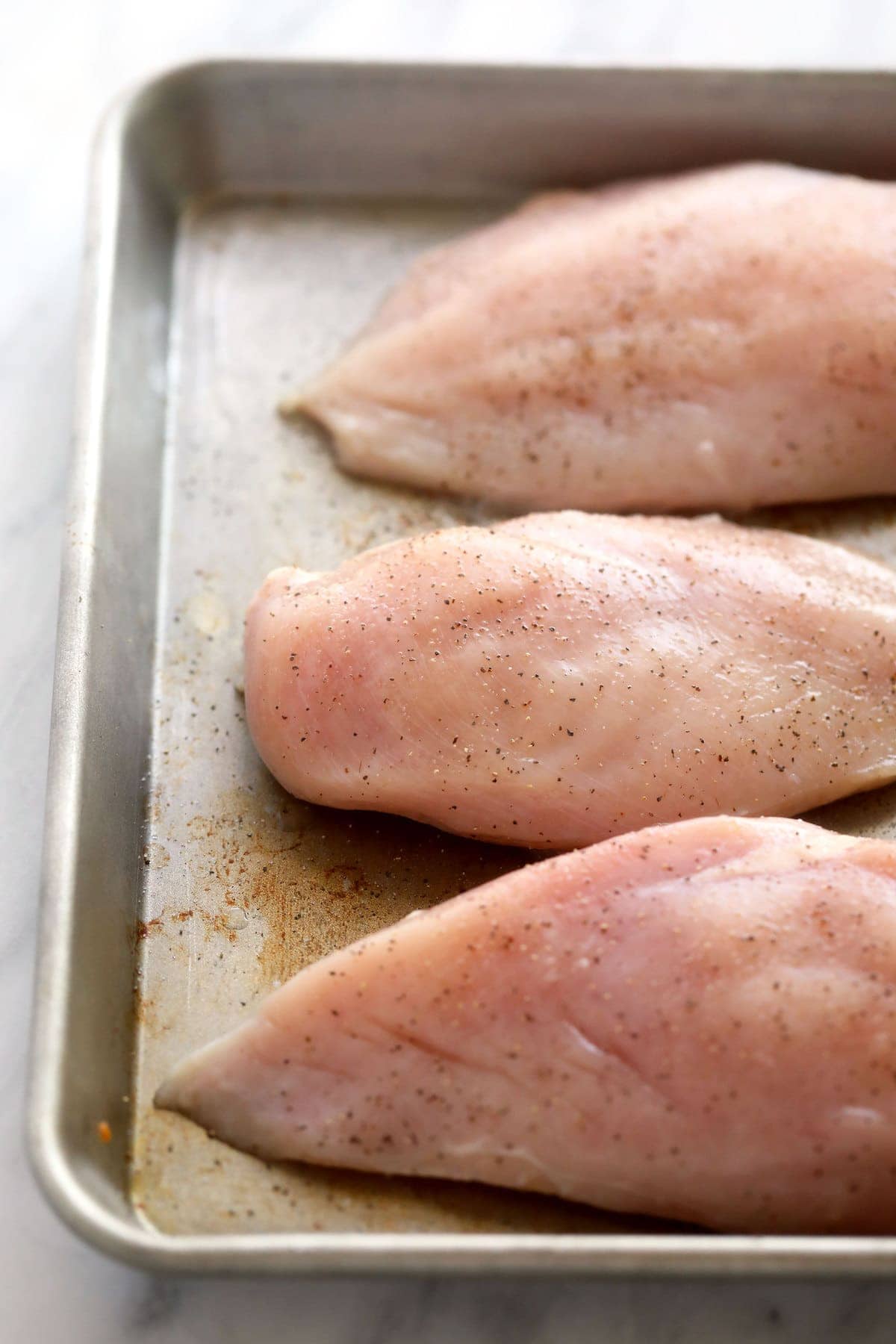 raw chicken breasts ready to be baked and then shredded