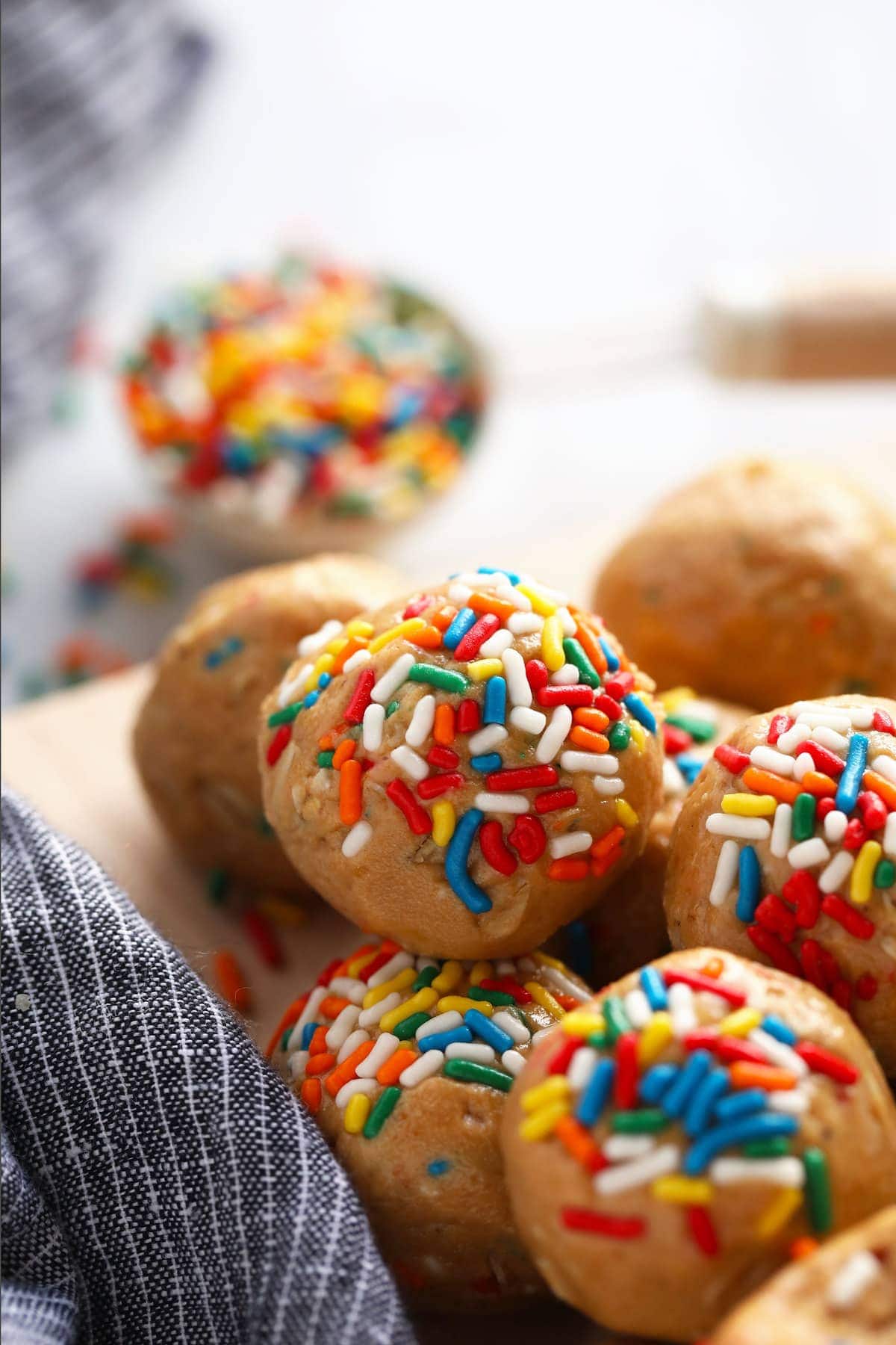 cake batter protein balls covered in rainbow sprinkles on a plate