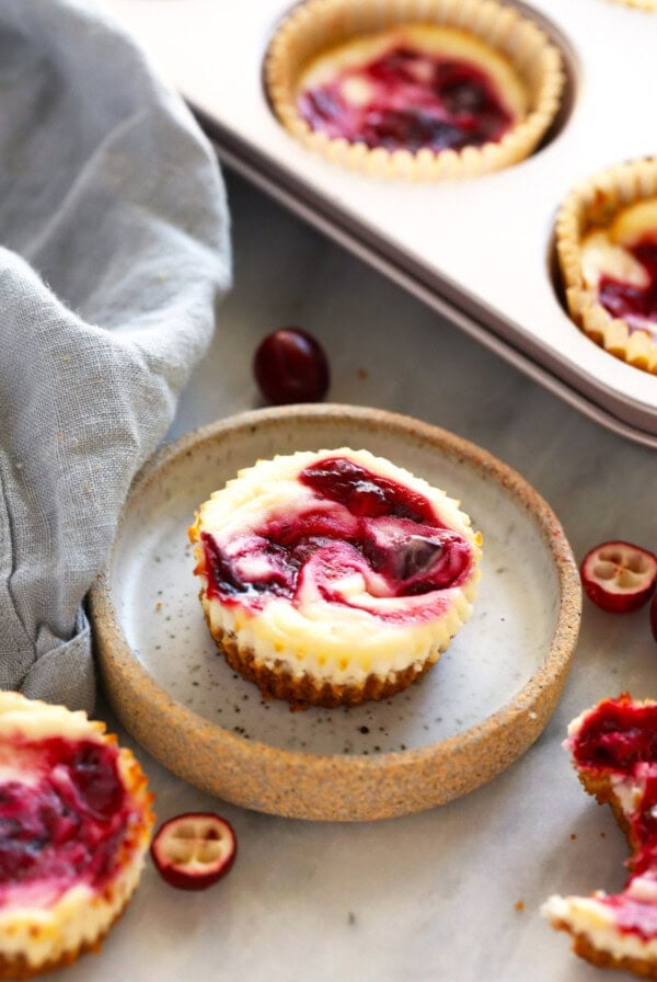 cranberry cheesecakes in a pan with cranberries.