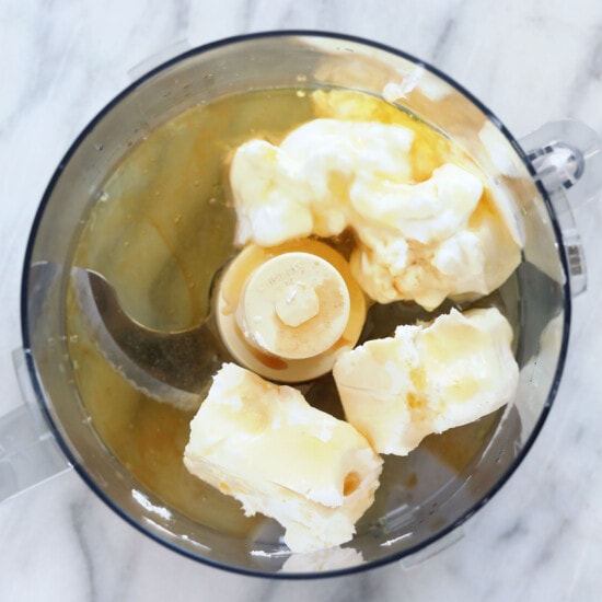 a food processor filled with butter and bananas.