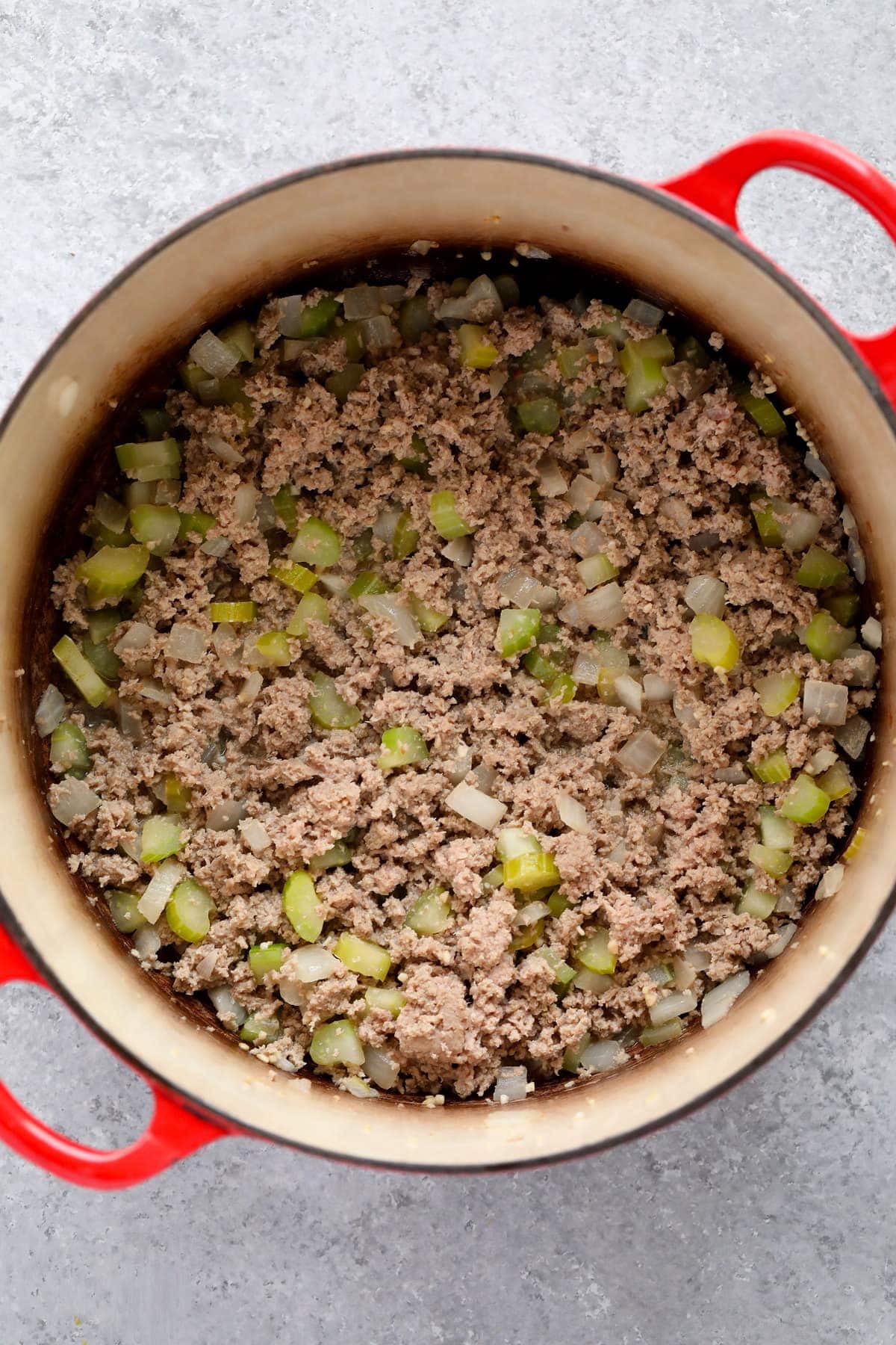 Ground turkey and vegetables being sauteed in a dutch oven for turkey chili.