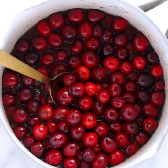Unique cranberry sauce recipe served in a white bowl with a spoon.