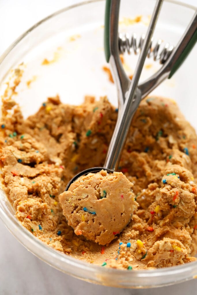 cake batter protein ball dough in a bowl being scooped into balls