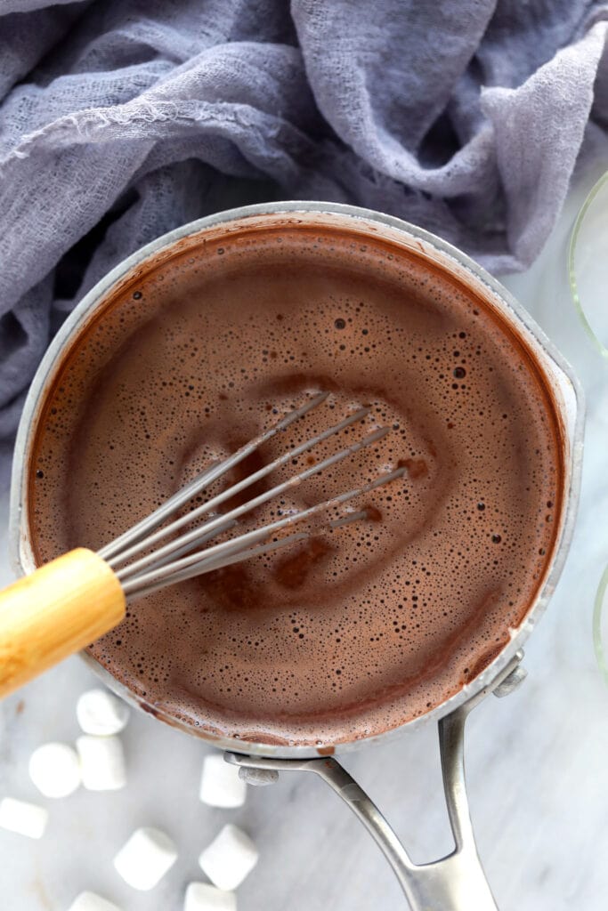 spiked hot chocolate in a pot being whisked together
