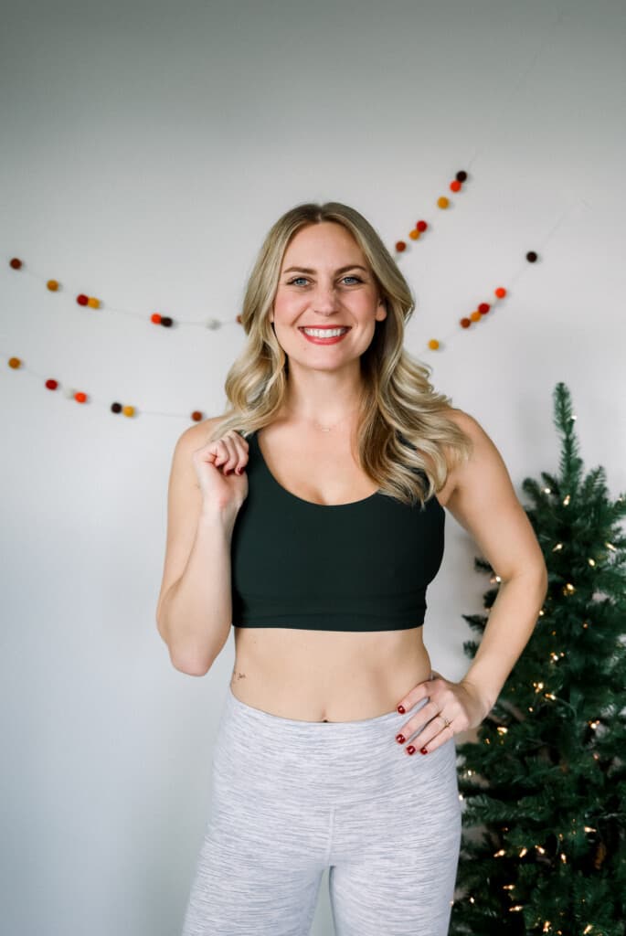 woman wearing a lululemon sports bra standing in front of a christmas tree
