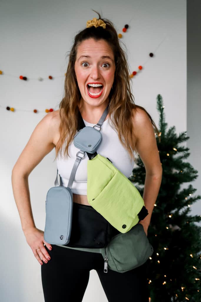 woman wearing three fanny packs and smiling