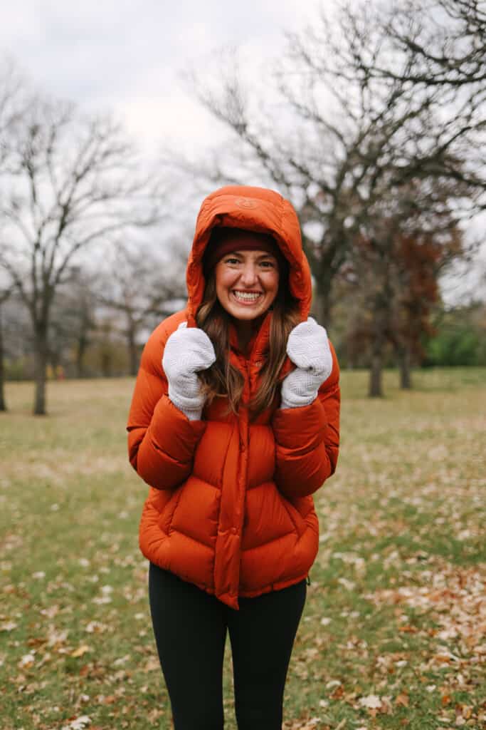 Woman in a puffy jacket smiling.