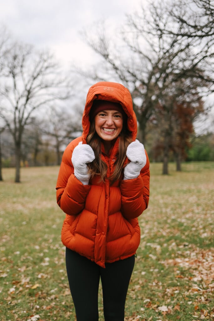 Woman in a puffy jacket smiling.