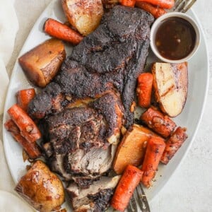 pork roast on platter with veggies.