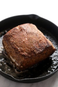 Slow cooker pork loin is being cooked in a skillet.