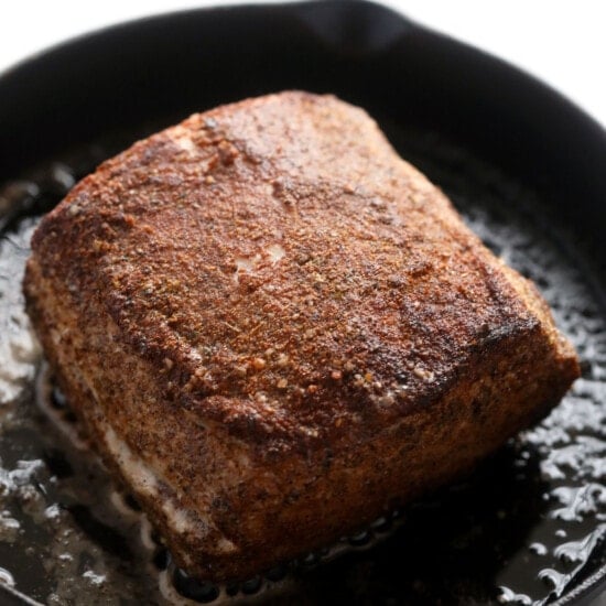 Slow cooker pork loin is being cooked in a skillet.
