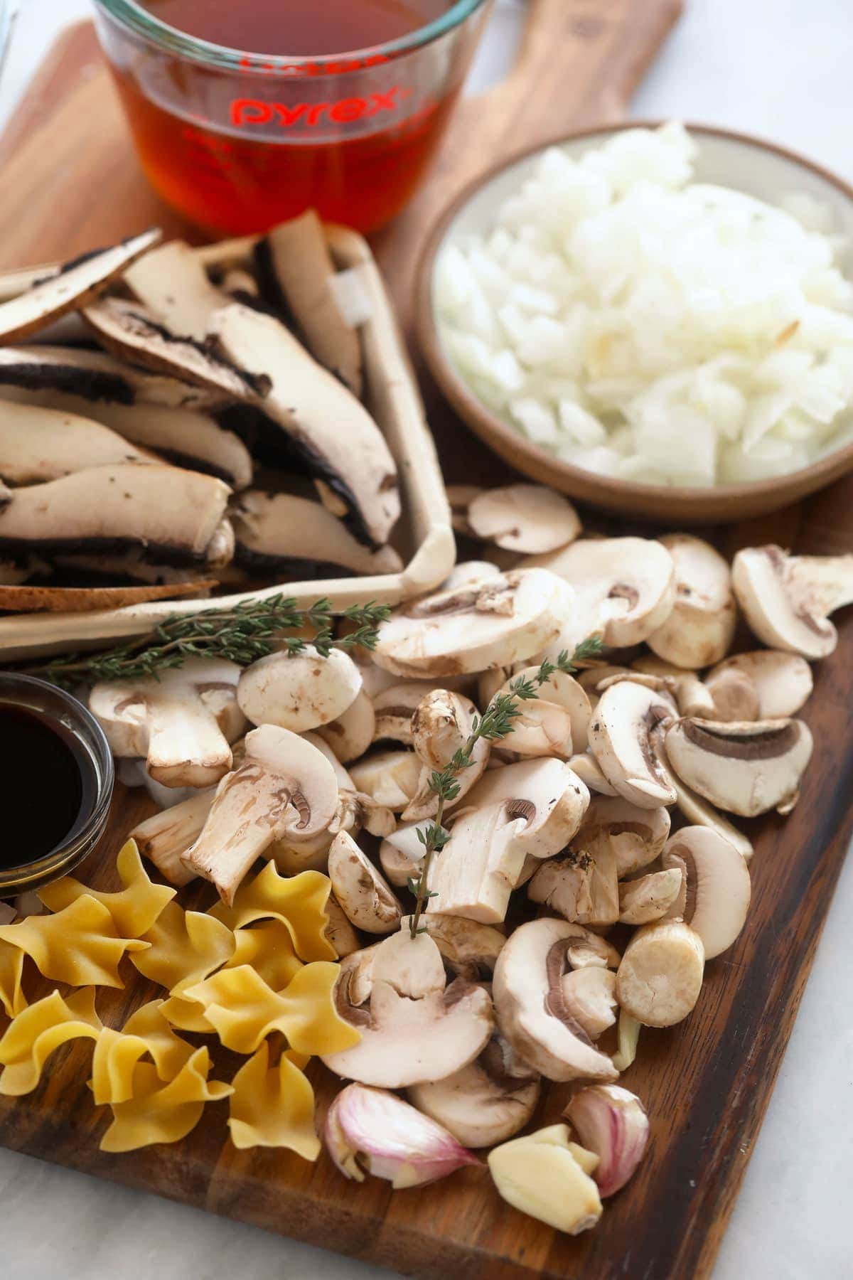 Mushroom stroganoff ingredients on a cutting board.