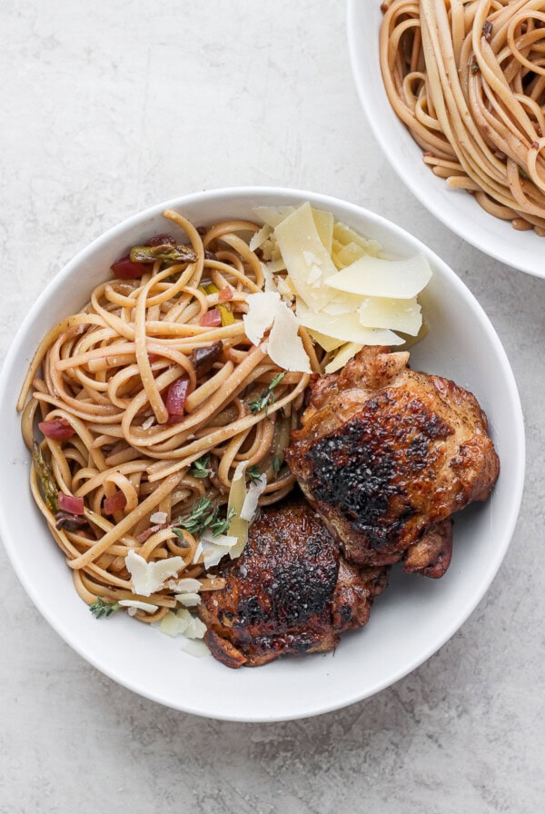 two bowls of pasta with chicken and parmesan.