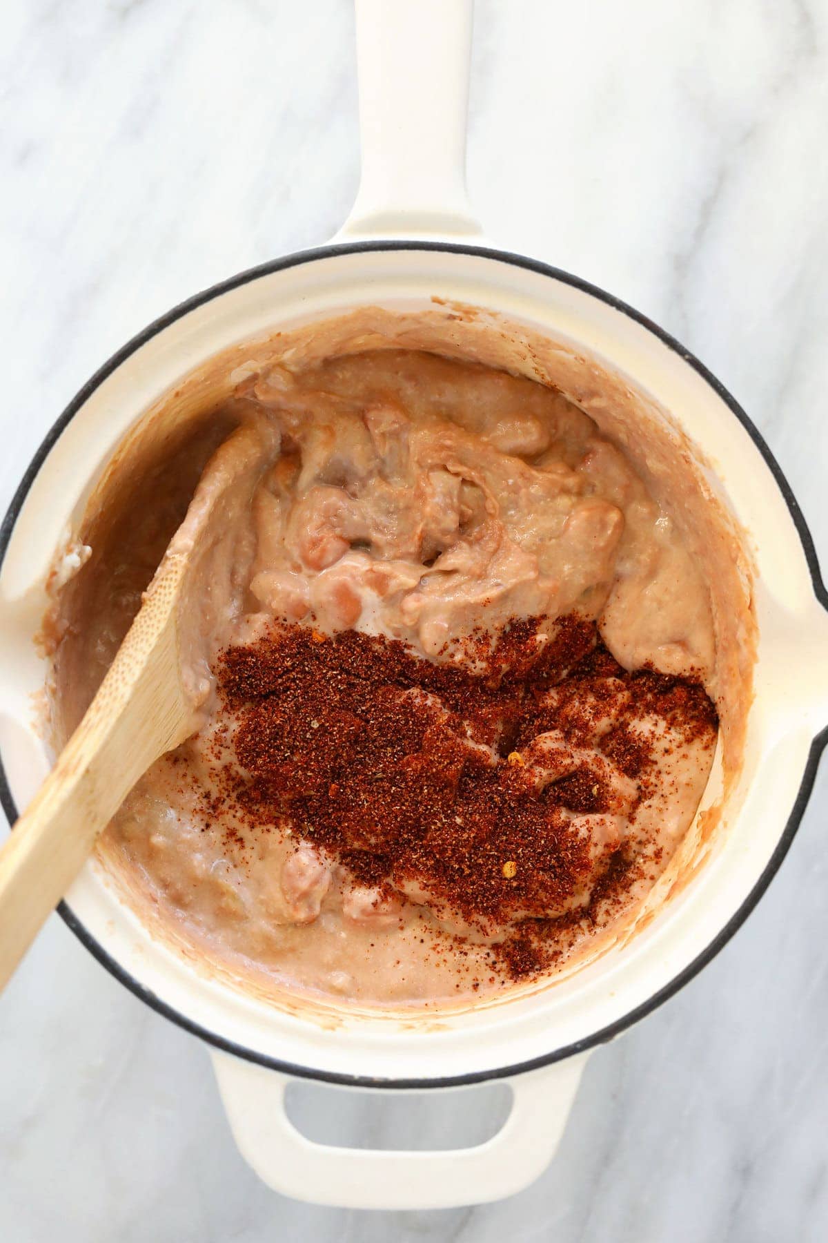 bean dip ingredients being mixed together in a skillet