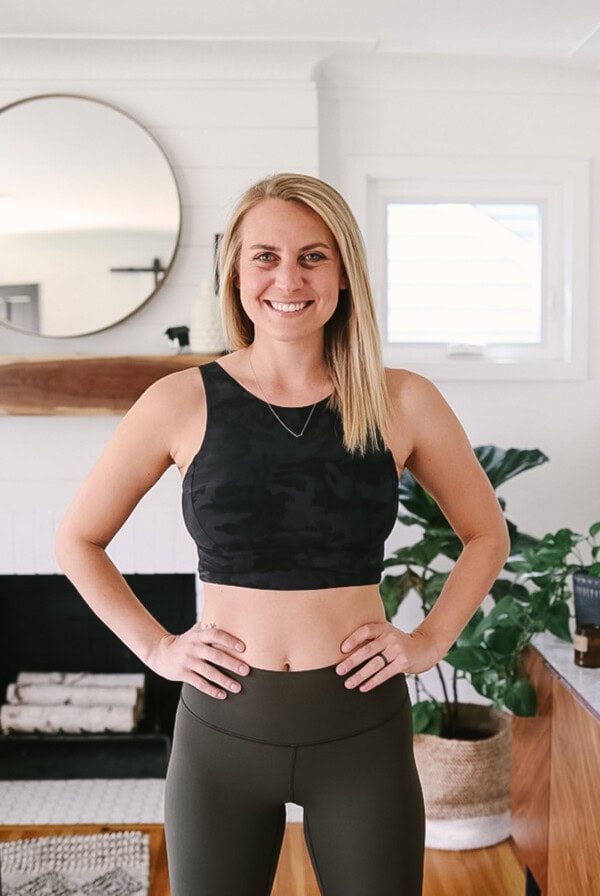 a woman in black leggings standing in a living room.