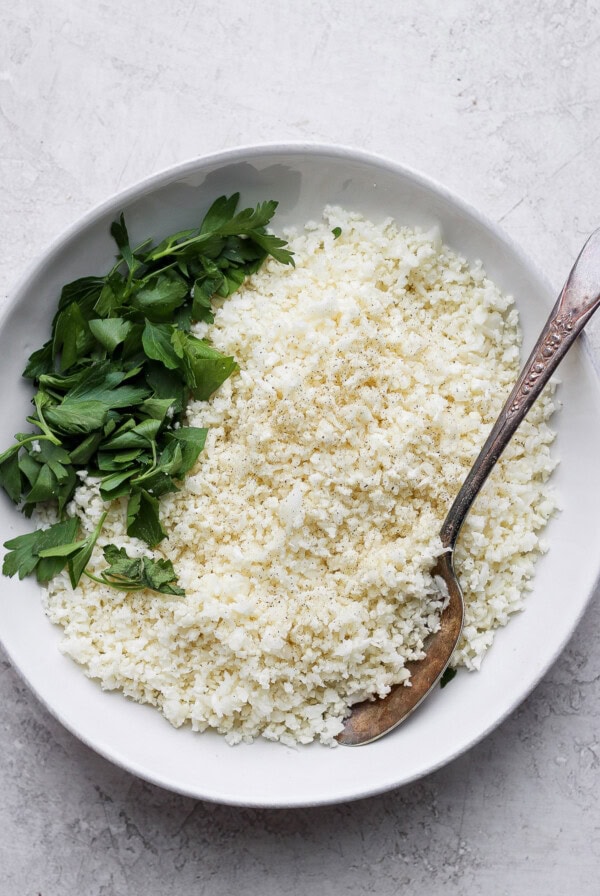 white rice and parsley in a white bowl.