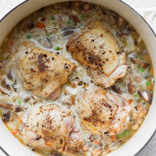 a pan with chicken and vegetables in it.