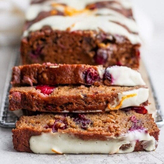A loaf of delectable cranberry orange bread topped with icing.