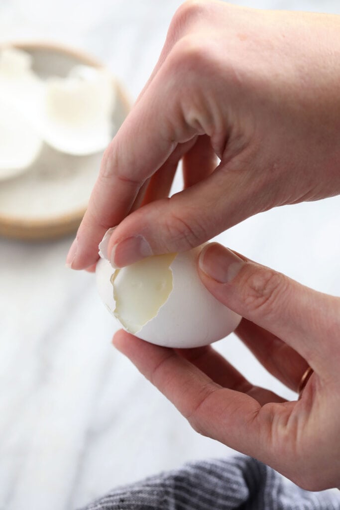 hand peeling hard boiled eggs