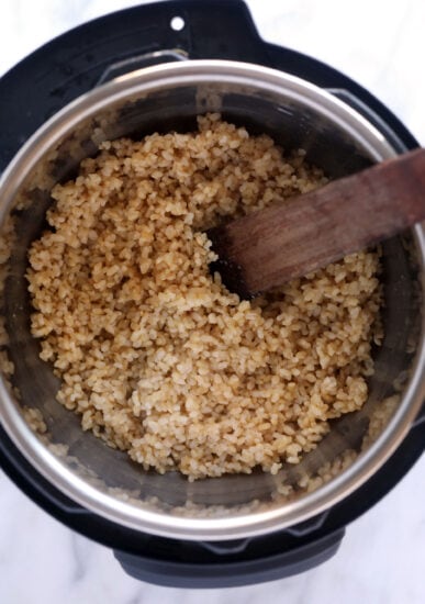 brown rice in an instant pot with a wooden spoon.