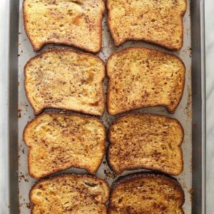 Four slices of french toast on a sheet pan.